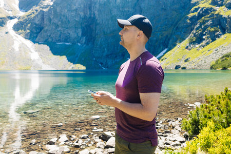 Beautiful panoramic view of a clear alpine lake surrounded by green forest and rugged mountain peaks...
