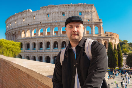 Handsome 30s tourist visiting Colosseum in Rome, Italy. Young man taking photo in front of famous...
