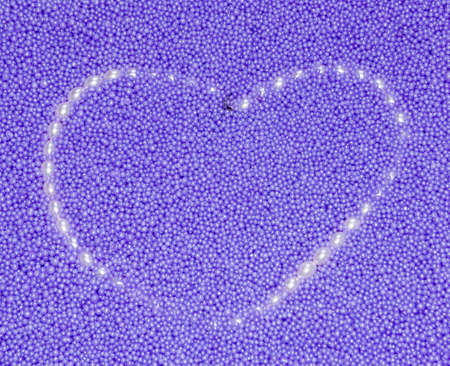 The image heart from pearls beads on a lilac backgroundの写真素材