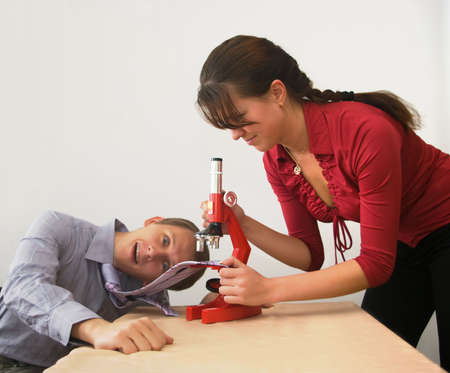 the Image of the wife considering a tie of the husband under a microscopeの写真素材