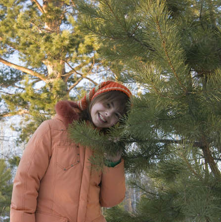 the Image of the girl sitting in snow with a pine branch in handsの写真素材
