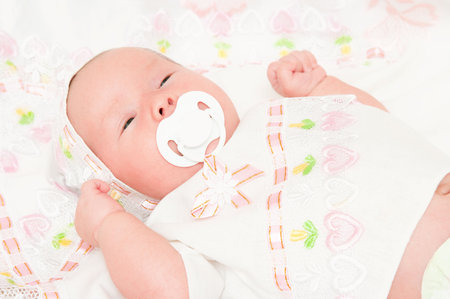 The newborn child sucks a dummy