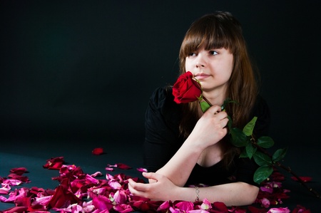 The image of the girl with a rose on a black backgroundの写真素材