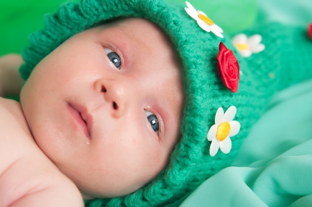 The image of the newborn child in green capの写真素材