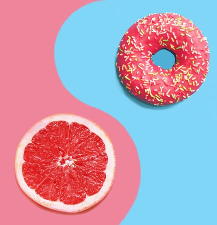 Donut on a blue background and pink grapefruit.の写真素材