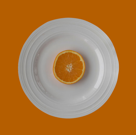 Slice of orange on a white plateの写真素材