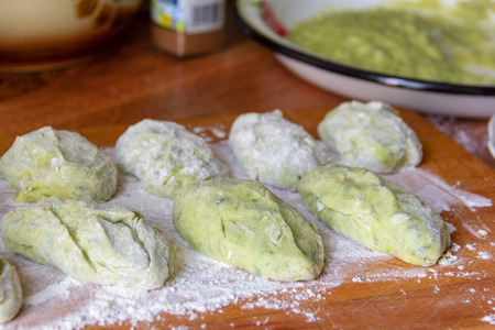green cutlets-a spinach dish with potatoes, eggs and flour, in the process of cooking on the tableの写真素材