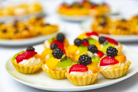 Appetizing pastries in the form of baskets with fruits, berries and nuts on a white plate. Candy bar...