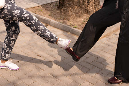 Alternative greeting with legs during the epidemic of coronavirus infection caused by the virus Covid-19. Maintaining the social distance between friends in a pandemic. Personal safety against infectionの写真素材