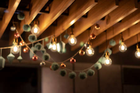 Blurred background, texture. Christmas garlands of bright balls, geometric shapes and retro lamps. Festive decor of lamps and Christmas toys for Christmas and New Year. Place for text Christmas background.の写真素材