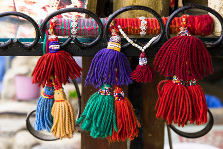 Oriental tassels made of wool decorated with beads. Ornament of brushes for clothes and interior. A beautiful handmade souvenir to protect from evil spirits and evil eyes.の写真素材