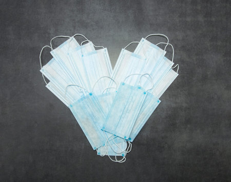 Heart from medical masks for Valentine's Day. Safe love during quarantine and an epidemic against a...