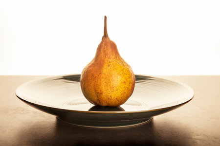 yellow pear on a ceramic plate on the table.の写真素材