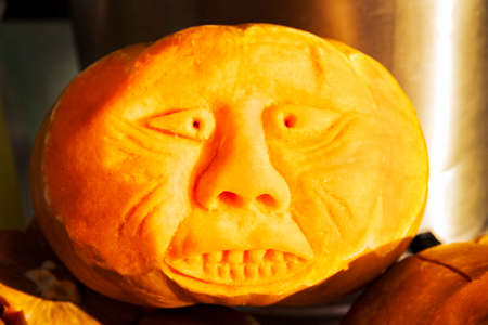 Vegetable carving. Halloween symbol. A scary face carved on a pumpkin for the holiday of Halloween. The mystical symbol of evil is All Saints Day. Soft focus.の写真素材