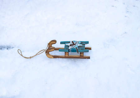 Decorations for Christmas and New Year. Christmas tree toy. Small wooden retro sled on the snow in the winter on the street. Christmas tree decoration sled. Christmas mood.の写真素材