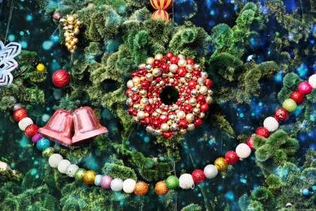 Festive background with a Christmas tree decorated with colorful toys, garlands and lights in bokeh. Christmas card with traditional attributes of winter holidays and blurry giland lightsの写真素材