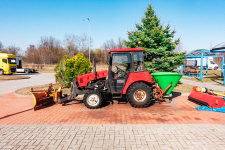 Old Belarus tractor for road works and sanding of the road. Tractor for carrying out road works and repairing the road surface in the parking lot. Modern road machines for road repairの写真素材