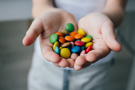 A child holding a handful of candy. Selective focus.の写真素材