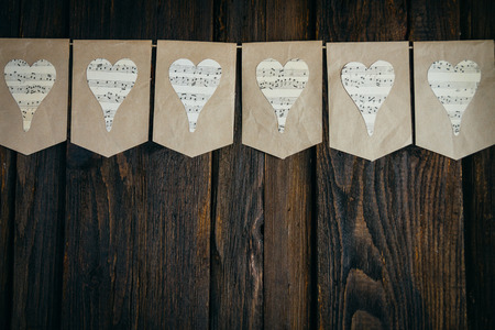 Garland handmade with hearts on a brown background with notesの写真素材