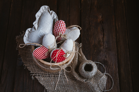 Hearts made of cloth with red white checkered pattern on rustic old wood with copy space, concept of love at Christmas, Mother's Day or Valentine's Dayの写真素材