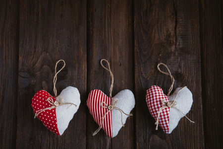 Hearts made of cloth with red white checkered pattern on rustic old wood with copy space, concept of love at Christmas, Mother's Day or Valentine's Dayの写真素材