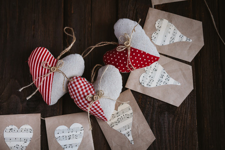Hearts made of cloth with red white checkered pattern on rustic old wood with copy space, concept of love at Christmas, Mother's Day or Valentine's Dayの写真素材