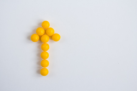 Vitamin C capsules in the form of arrow on white background. Healthy eating concept. Selective focus.の写真素材