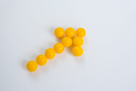 Vitamin C capsules in the form of arrow on white background. Healthy eating concept. Selective...