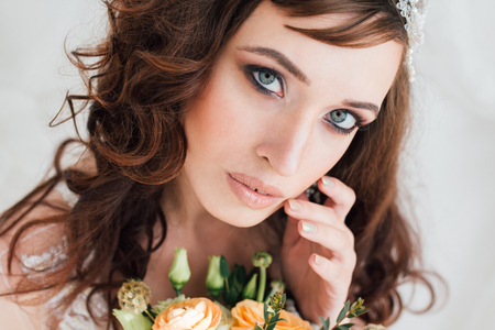 Boudoir bride's morning. Young beautiful woman with a bouquet in a negligee preparing for their wedding day. Toning.の写真素材