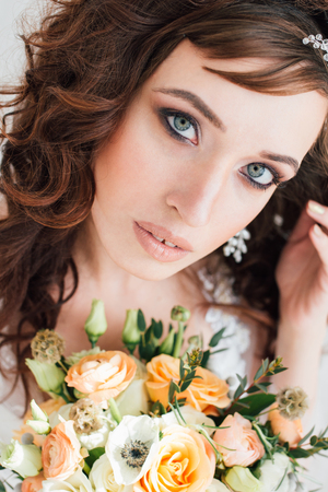 Boudoir bride's morning. Young beautiful woman with a bouquet in a negligee preparing for their wedding day. Toning.の写真素材