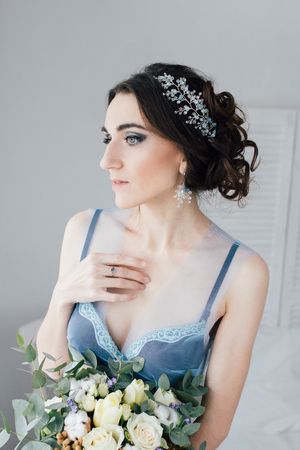 Boudoir bride's morning. Young beautiful woman with a bouquet in a negligee preparing for their wedding day. Toning.の写真素材