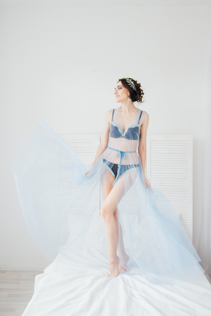 Boudoir bride's morning. Young beautiful woman with a bouquet in a negligee preparing for their wedding day. Toning.の写真素材