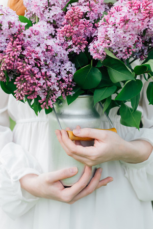 Bouquet of lilac in the hands of a woman in the spring garden. Toning.の写真素材