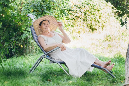 Portrait of an elderly woman in a hat lying on the sunbed. Toning. Selective focus.の写真素材