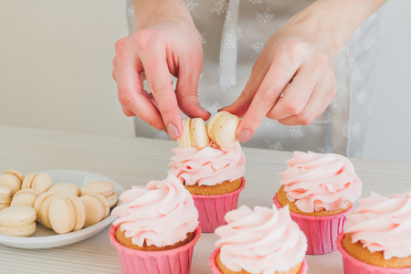Young girl prepares cupcakes. Decorating cupcakes. The concept of home cooking. Selective focus. Toning.の写真素材