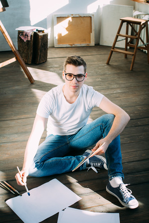 Young man  artist paints a picture in the Studio. Toning.の写真素材