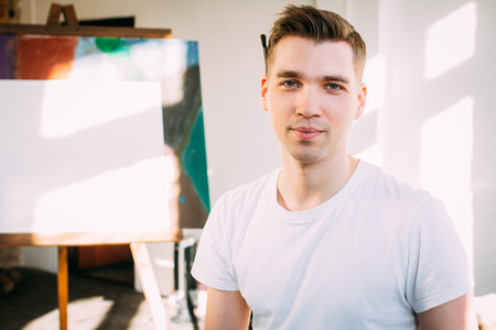 Young man  artist paints a picture in the Studio. Toning.の写真素材