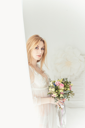 Boudoir bride's morning. Young beautiful woman in a negligee preparing for their wedding day. Toning.の写真素材
