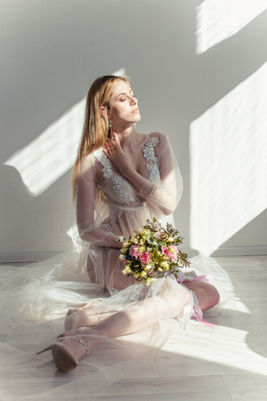 Boudoir bride's morning. Young beautiful woman in a negligee preparing for their wedding day. Toning.の写真素材