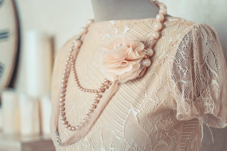 Delicate composition with a dress on a mannequin decorated in retro style. Selective focus. Vintage...