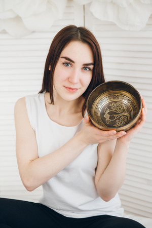 Massage therapist plays on singing bowls for a vibrational massage in the Spa. The concept of relaxation and alternative medicine. Toning.の写真素材