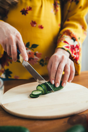 Young cute pregnant girl preparing vegetable salad in the kitchen. The concept of healthy eating. Toning.の写真素材