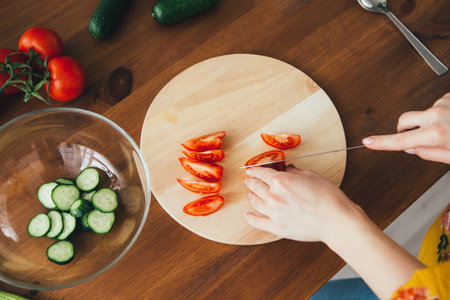 Young cute pregnant girl preparing vegetable salad in the kitchen. The concept of healthy eating. Toning.の写真素材