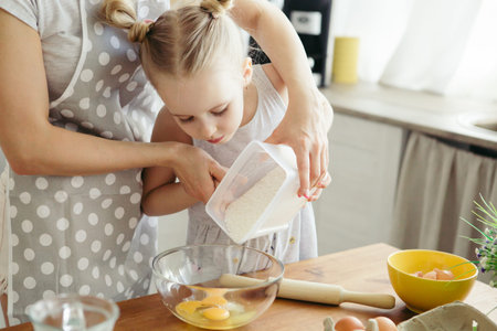 Cute little girl helps mom bake cookies in the kitchen. Happy family. Toning.
