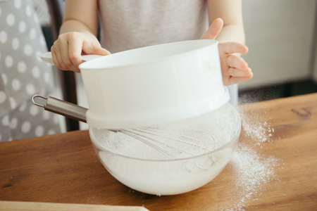 Cute little girl helps mom bake cookies in the kitchen. Happy family. Toning.の写真素材