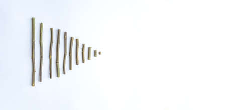 A simple composition of dry sticks in the shape of a triangle, arrows on a white background. space for text. Postcard, pointer, bannerの写真素材