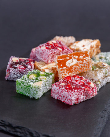 Lukum, a set of Arabic sweets, a national Turkish dessert on a black background. Top view, close-up
