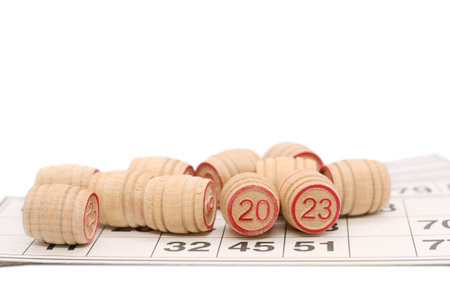 A lotto board game on a white background. Wooden barrels for lotto with playing cards. Two lying barrels show the number 2023.の写真素材
