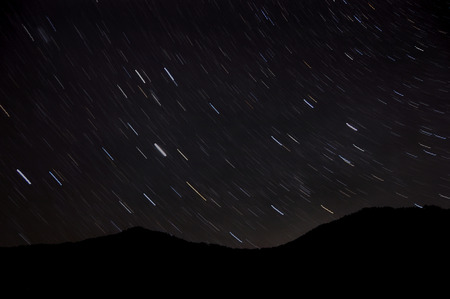 Night mountain landscape with stars in the form of tracks, shot long exposureの写真素材