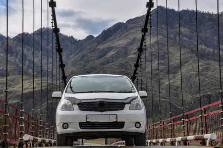 White car on the bridge in a picturesque location in the mountainsの写真素材